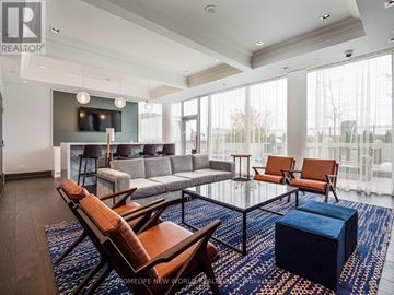 Markham (Unionville) condo for rent - A living room with a blue rug and brown leather chairs.
