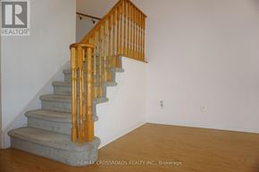 Markham (Unionville) townhouse for rent - A wooden staircase with a light brown banister and beige steps leads up to a white wall.