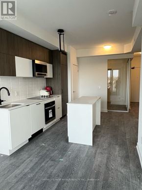 Richmond Hill (South Richvale) condo for rent - A modern kitchen with white cabinets and a microwave above the stove.