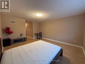 Toronto (Newtonbrook West) townhouse for rent - A bedroom with a bed, a chair, and a balloon decoration.