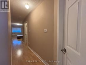 Toronto (Newtonbrook West) townhouse for rent - A hallway with a door on the right and a window with blinds on the left.