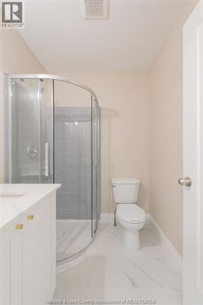 Windsor apartment for rent - A white bathroom with a toilet, sink, and shower.