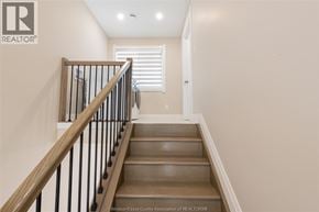 Windsor apartment for rent - A staircase with wooden steps and a black railing.
