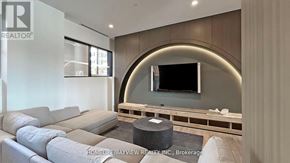 Vaughan (Beverley Glen) condo for rent - A modern living room with a grey sofa and a flat screen TV mounted on the wall.