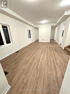 Caledon (Bolton East) apartment for rent - A long hallway with wood flooring and white walls.