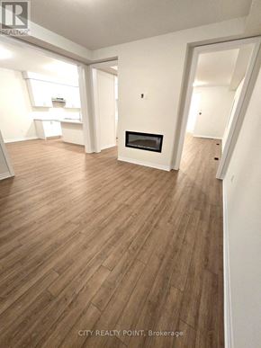 Caledon (Bolton East) apartment for rent - A wood floor in a white room with a fireplace.