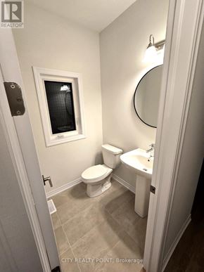 Caledon (Bolton East) apartment for rent - A white bathroom with a toilet, sink and mirror.