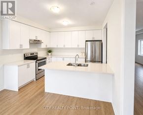 Caledon (Bolton East) apartment for rent - A kitchen with white cabinets and a wooden floor.