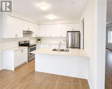 Caledon (Bolton East) apartment for rent - A kitchen with white cabinets and a wooden floor.