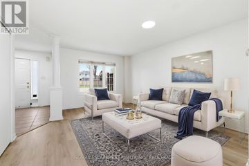 Newmarket (Bristol-London) townhouse for rent - A well-lit, modern living room with a white sofa, a grey coffee table, and a large painting on the wall.