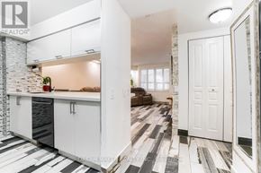 Richmond Hill (Beaver Creek Business Park) condo for rent - A modern kitchen with white cabinets and a stone backsplash.
