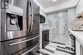 Richmond Hill (Beaver Creek Business Park) condo for rent - A modern kitchen with a stainless steel refrigerator and a black and white tiled backsplash.