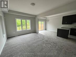 Niagara Falls (Cherrywood) townhouse for rent - A spacious room with grey carpeting and a black cabinet.
