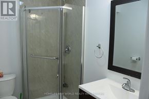 Toronto (Rockcliffe-Smythe) townhouse for rent - A white sink with a silver faucet and a glass shower door.