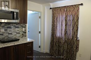 Toronto (Rockcliffe-Smythe) townhouse for rent - A kitchen with a stone backsplash and a microwave above the counter.