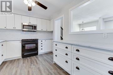 Essa (Angus) apartment for rent - A kitchen with white cabinets and a wood floor.