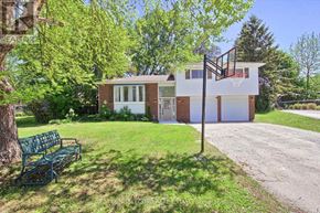 Essa (Angus) apartment for rent - A house with a white garage door and a red door is surrounded by greenery.
