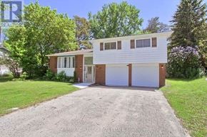 Essa (Angus) apartment for rent - A two-story house with a garage is surrounded by greenery.