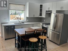 Toronto (Lambton Baby Point) apartment for rent - A kitchen with a wooden table and stools.