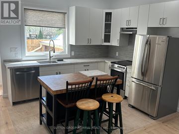 Toronto (Lambton Baby Point) apartment for rent - A kitchen with a wooden table and stools.