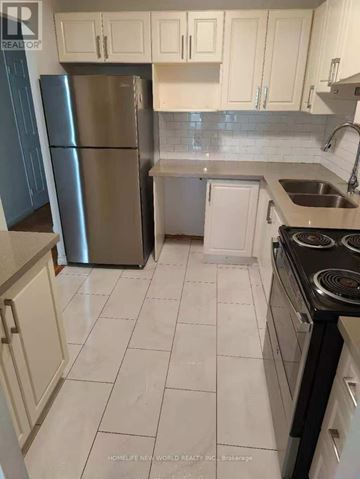 Toronto (Agincourt South-Malvern West) condo for rent - A kitchen with white cabinets and a stainless steel refrigerator.