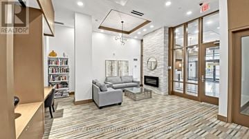 Markham (Wismer) condo for rent - A living room with a grey couch and a fireplace.