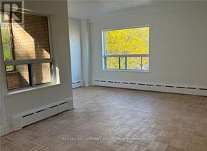 Hamilton (Durand) condo for rent - A room with a large window and a wooden floor.