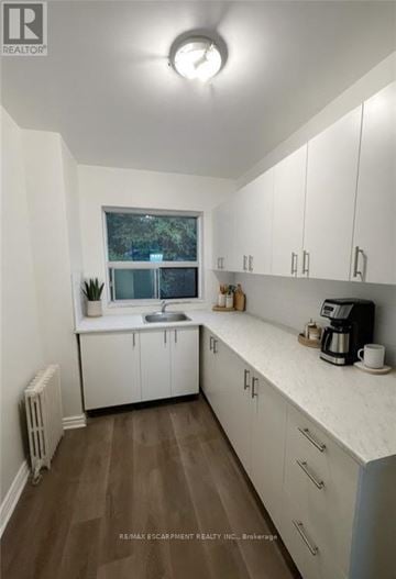 Hamilton (Durand) condo for rent - A kitchen with white cabinets and a window.