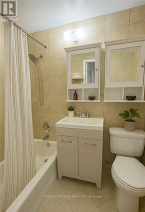 Hamilton (Durand) condo for rent - A white bathroom with a toilet, sink, and shower.