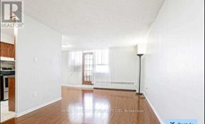 Toronto (Dorset Park) condo for rent - A spacious room with wooden flooring and white walls, featuring a window with blinds and a radiator beneath it.