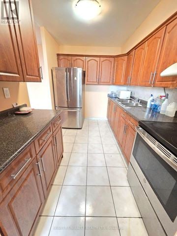 Toronto (Dorset Park) condo for rent - A kitchen with wooden cabinets and a black counter top.