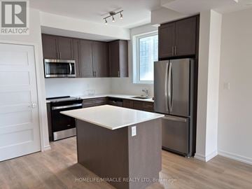 Newmarket (Glenway Estates) townhouse for rent - A kitchen with a white island and dark brown cabinets.