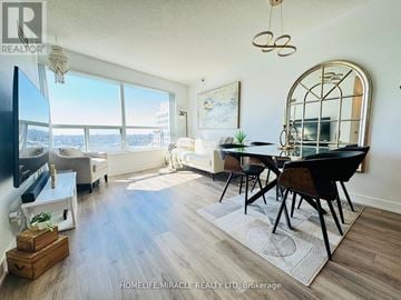 Toronto (Woburn) condo for rent - A well-lit living room with a dining table and chairs.