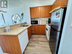 Toronto (Woburn) condo for rent - A kitchen with wooden cabinets and a white fridge.