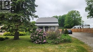 Springwater (Elmvale) apartment for rent - A house with a grey roof and a garden in front.
