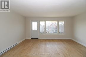 Peterborough (Town Ward 3) triplex for rent - A room with a door and a window, with a view of a red house across the street.