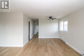 Peterborough (Town Ward 3) triplex for rent - A spacious room with a ceiling fan and wooden flooring.