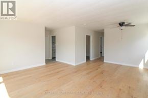 Peterborough (Town Ward 3) triplex for rent - A spacious room with wooden flooring and a ceiling fan.