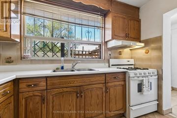 Toronto (Oakwood Village) apartment for rent - A kitchen with wooden cabinets and a white stove.