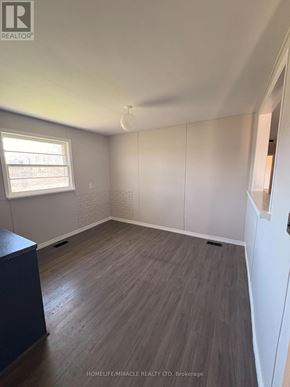 Richmond Hill apartment for rent - A room with wooden flooring and white walls.
