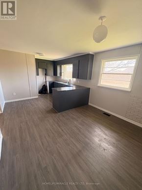 Richmond Hill apartment for rent - A real estate listing photo of a kitchen with a large island and wood flooring.