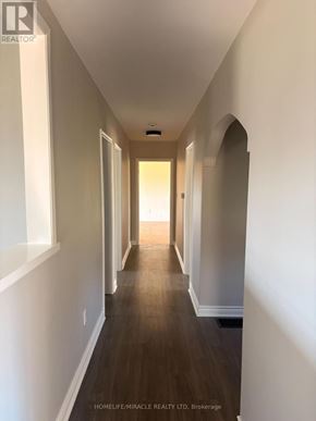 Richmond Hill apartment for rent - A long hallway with white walls and wood floors.