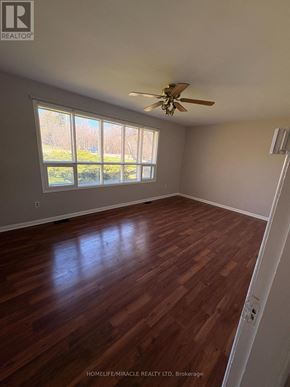 Richmond Hill apartment for rent - A room with wooden floors and a ceiling fan.