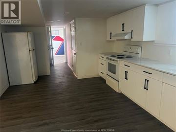 Windsor apartment for rent - A kitchen with white cabinets and a wooden floor.