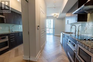 Toronto (Waterfront Communities) condo for rent - A kitchen with dark wood cabinets and stainless steel appliances.