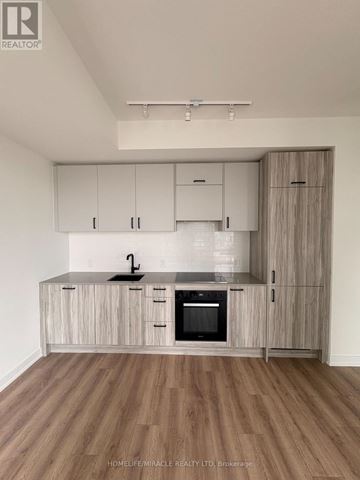 Toronto (Banbury-Don Mills) condo for rent - A kitchen with wooden cabinets and a black oven.