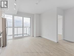 Oshawa (Windfields) condo for rent - A spacious, empty room with a view of the water outside the large windows.