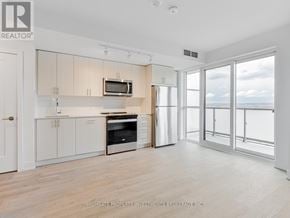 Oshawa (Windfields) condo for rent - A spacious kitchen with white cabinets and a microwave above the oven.