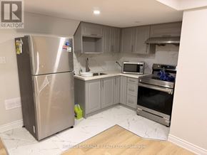 Caledon apartment for rent - A kitchen with a stainless steel refrigerator, microwave, oven, and sink.