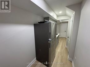 Caledon apartment for rent - A black refrigerator in a narrow hallway with white walls.